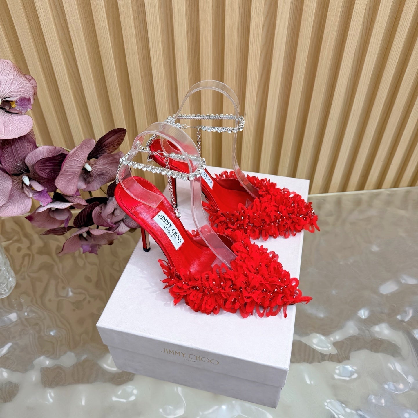 БОСОНІЖКИ JIMMY CHOO 26S НА ВИСОКОМУ КАБЛУЦІ 100 ММ ІЗ ЧЕРВОНОЇ ТКАНИНИ ТА ОВЕЧОЇ ШКІРИ ЗІ СТРАЗАМИ