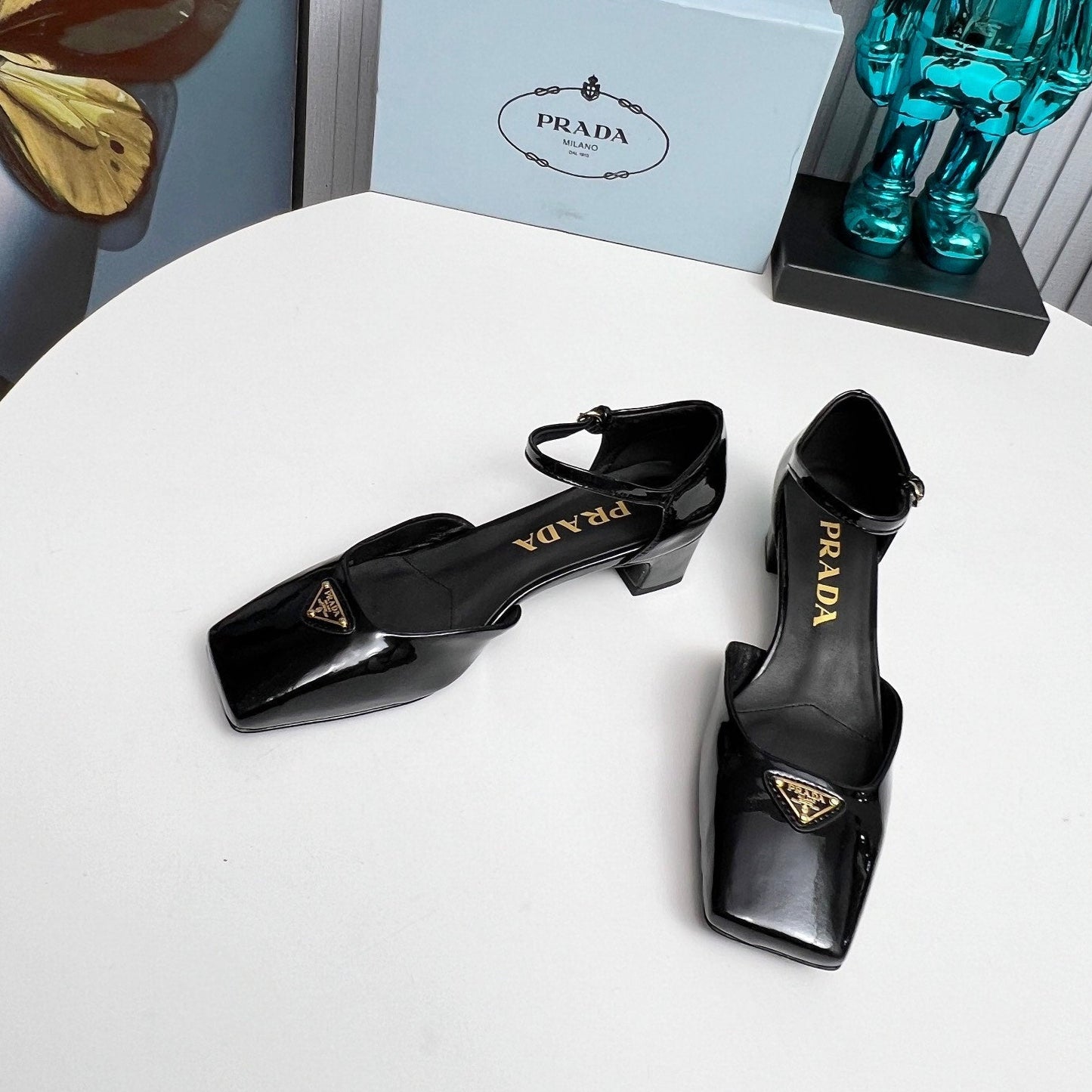 БОСОНІЖКИ PRADA 26S З РЕМІНЦЕМ НА ЩИКОЛОТЦІ НА ПІДБОРАХ 40 ММ З ЧОРНОЇ ЛАКОВАНОЇ ТЕЛЯЧОЇ ШКІРИ З ЛОГОТИПОМ У ВИГЛЯДІ ТРИКУТНИКА