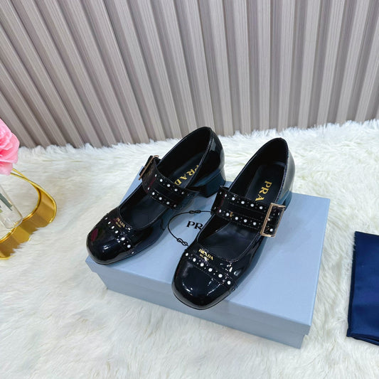 ЖІНОЧІ ТУФЛІ PRADA МЕРІ ДЖЕЙН 26S З ЗАКРУГЛЕНИМ НОСКОМ, ВИСОТА ПІДОШВИ 40 ММ, З ЧОРНОЇ ЛАКОВАНОЇ ТЕЛЯЧОЇ ШКІРИ З ДЕТАЛЯМИ У ВИГЛЯДІ ЗАКЛЬОПОК