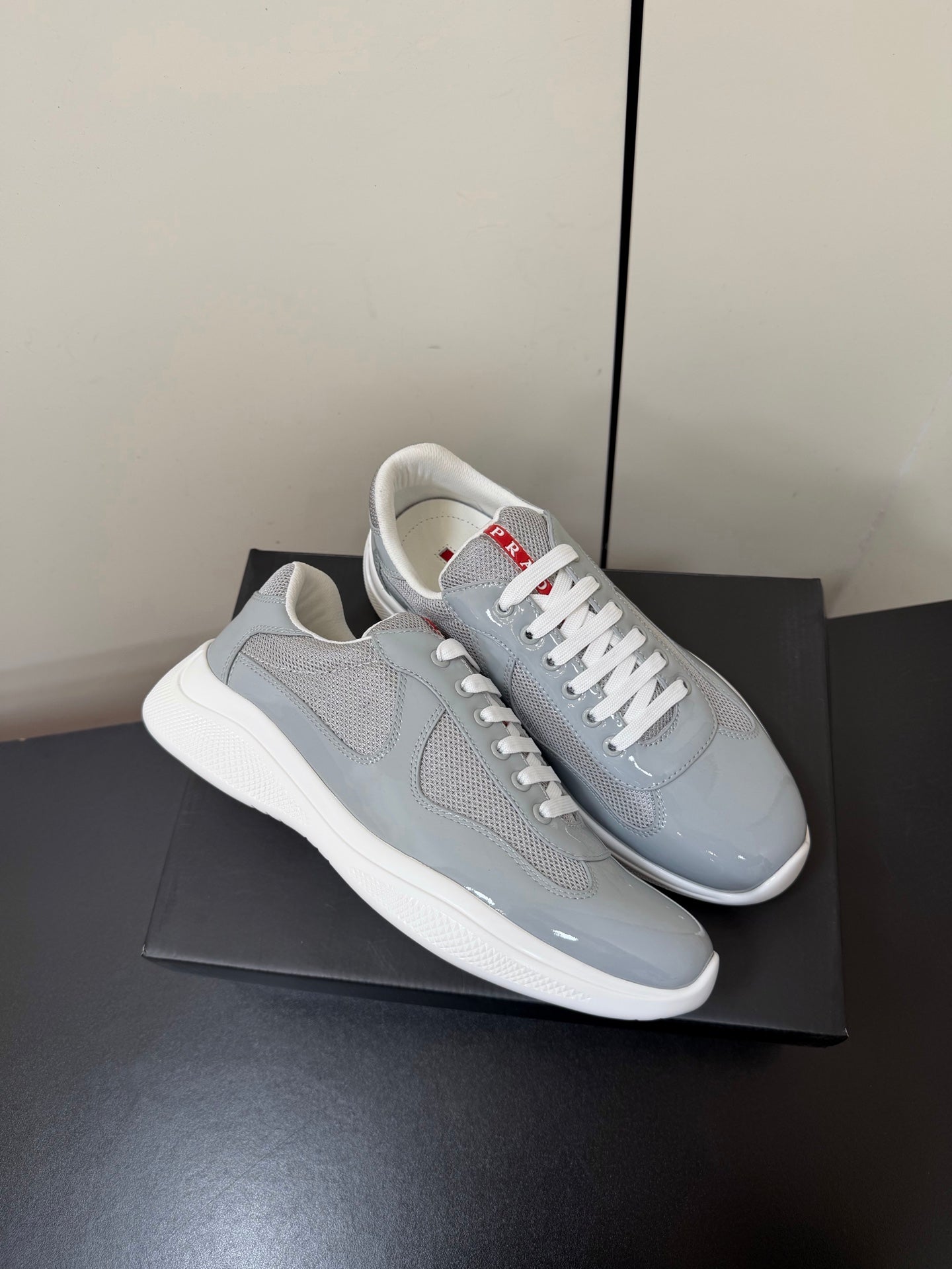 КРОСІВКИ PRADA 26S ЗІ СВІТЛО-СІРОЇ ЛАКОВАНОЇ ТЕЛЯЧОЇ ШКІРИ ТА БІЛОЇ СІТКИ