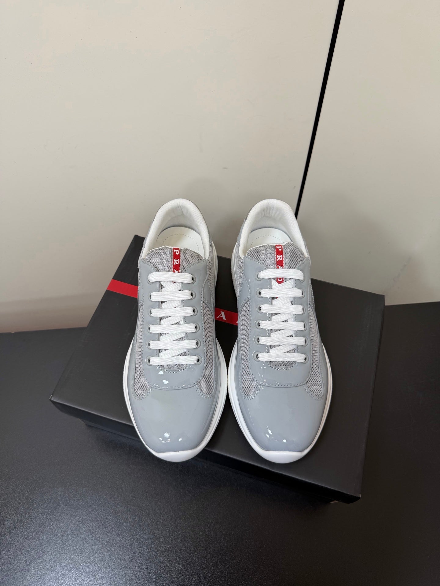 КРОСІВКИ PRADA 26S ЗІ СВІТЛО-СІРОЇ ЛАКОВАНОЇ ТЕЛЯЧОЇ ШКІРИ ТА БІЛОЇ СІТКИ