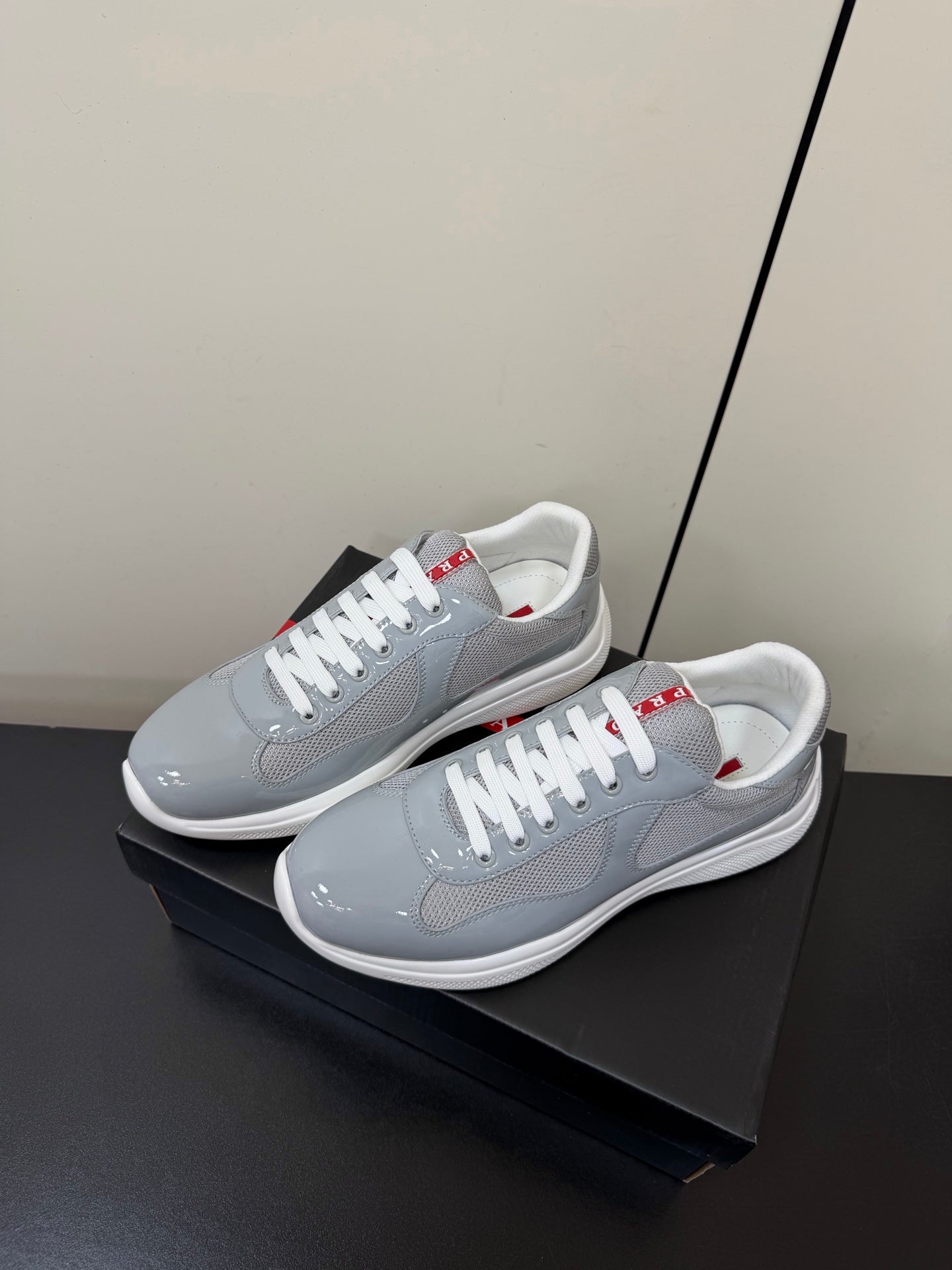 КРОСІВКИ PRADA 26S ЗІ СВІТЛО-СІРОЇ ЛАКОВАНОЇ ТЕЛЯЧОЇ ШКІРИ ТА БІЛОЇ СІТКИ