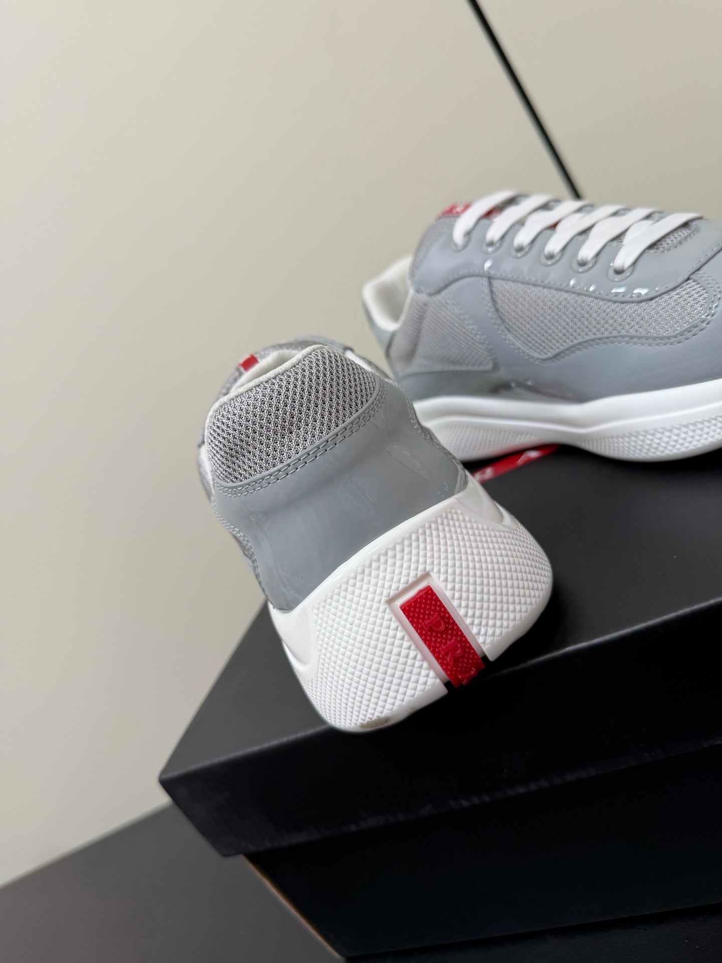 КРОСІВКИ PRADA 26S ЗІ СВІТЛО-СІРОЇ ЛАКОВАНОЇ ТЕЛЯЧОЇ ШКІРИ ТА БІЛОЇ СІТКИ
