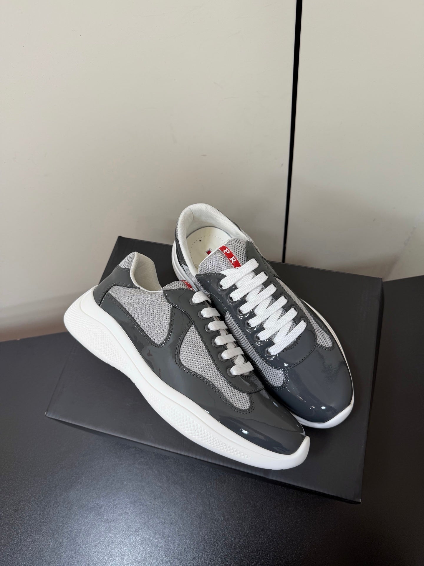 Кросівки PRADA 26S з сірої лакованої телячої шкіри та білої сітки