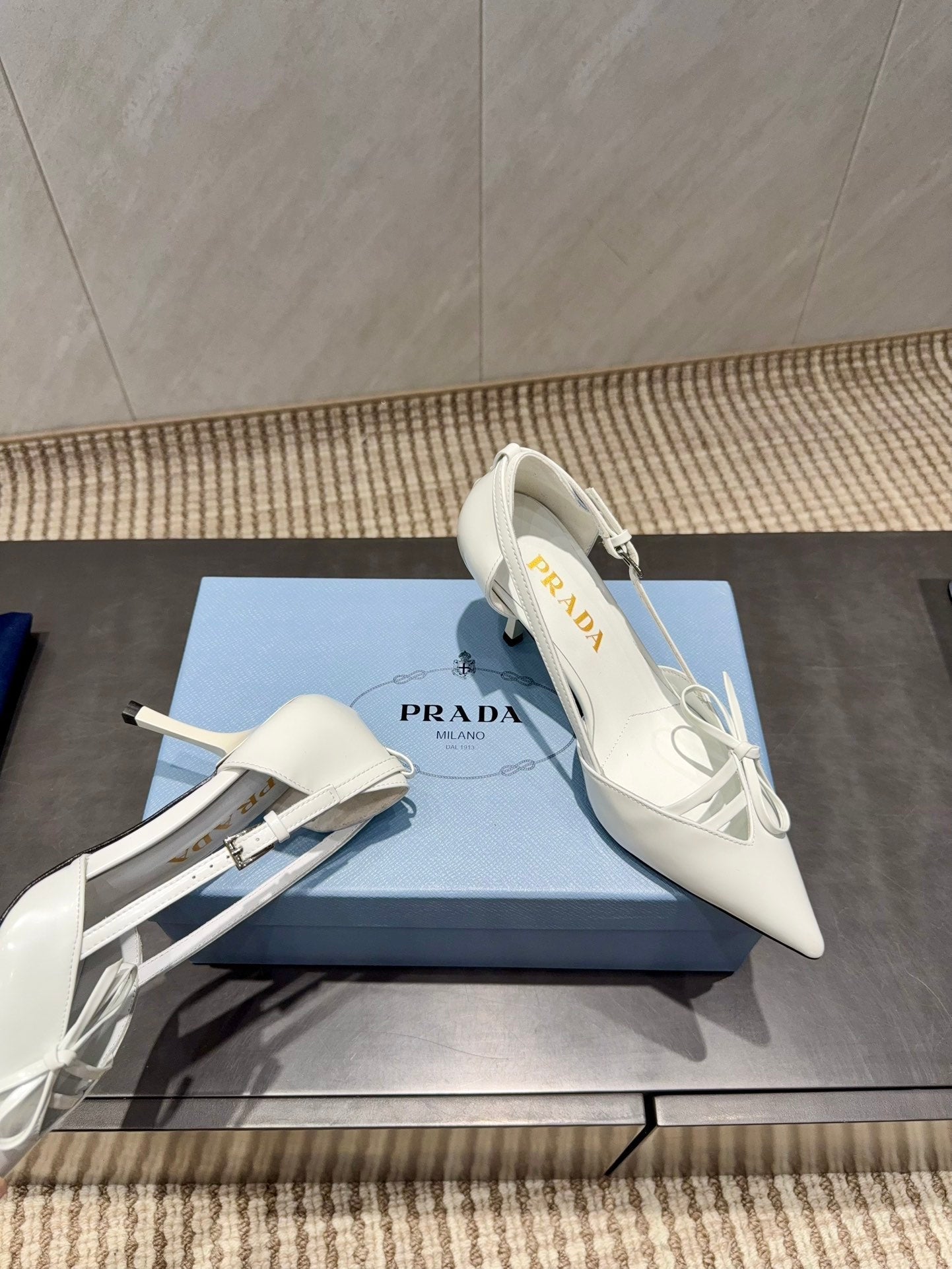 ЖІНОЧІ ТУФЛІ PRADA 26S НА ВИСОКИХ ПІДБОРАХ 75 ММ ІЗ ЗАГОСТРЕНИМ НОСКОМ ТА ВИРІЗАМИ З БІЛОЇ ТЕЛЯЧОЇ ШКІРИ З БАНТОМ
