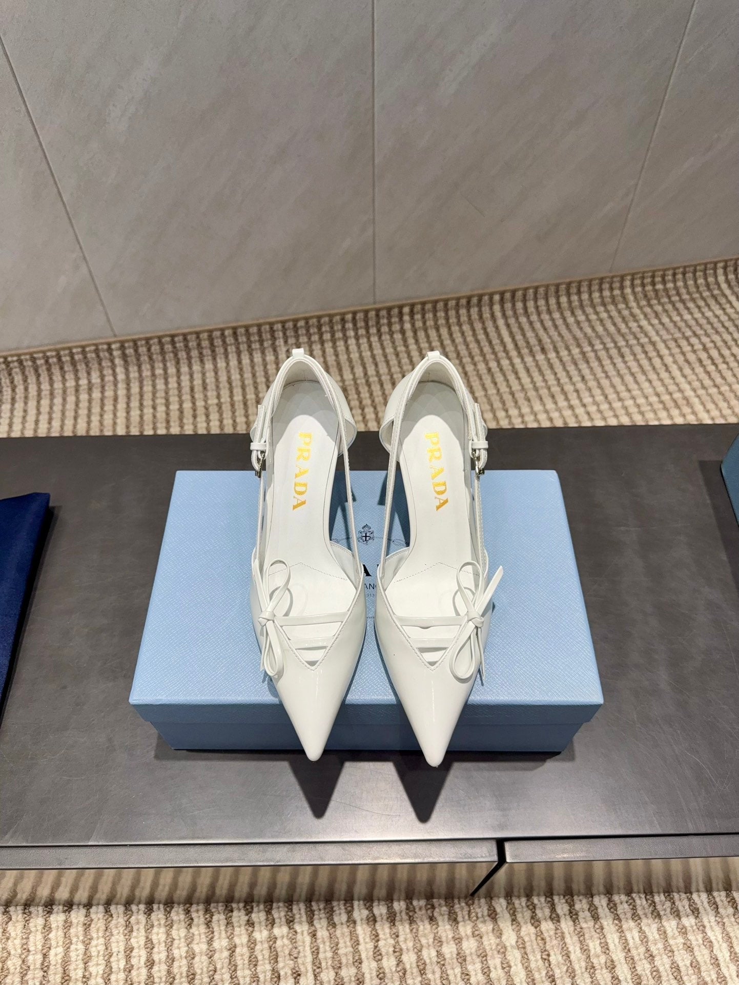 ЖІНОЧІ ТУФЛІ PRADA 26S НА ВИСОКИХ ПІДБОРАХ 75 ММ ІЗ ЗАГОСТРЕНИМ НОСКОМ ТА ВИРІЗАМИ З БІЛОЇ ТЕЛЯЧОЇ ШКІРИ З БАНТОМ