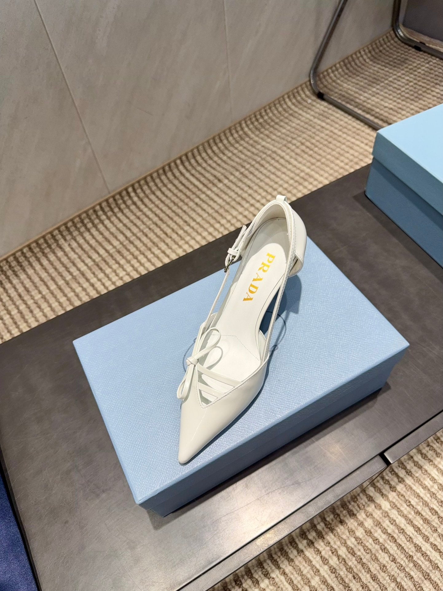 ЖІНОЧІ ТУФЛІ PRADA 26S НА ВИСОКИХ ПІДБОРАХ 75 ММ ІЗ ЗАГОСТРЕНИМ НОСКОМ ТА ВИРІЗАМИ З БІЛОЇ ТЕЛЯЧОЇ ШКІРИ З БАНТОМ