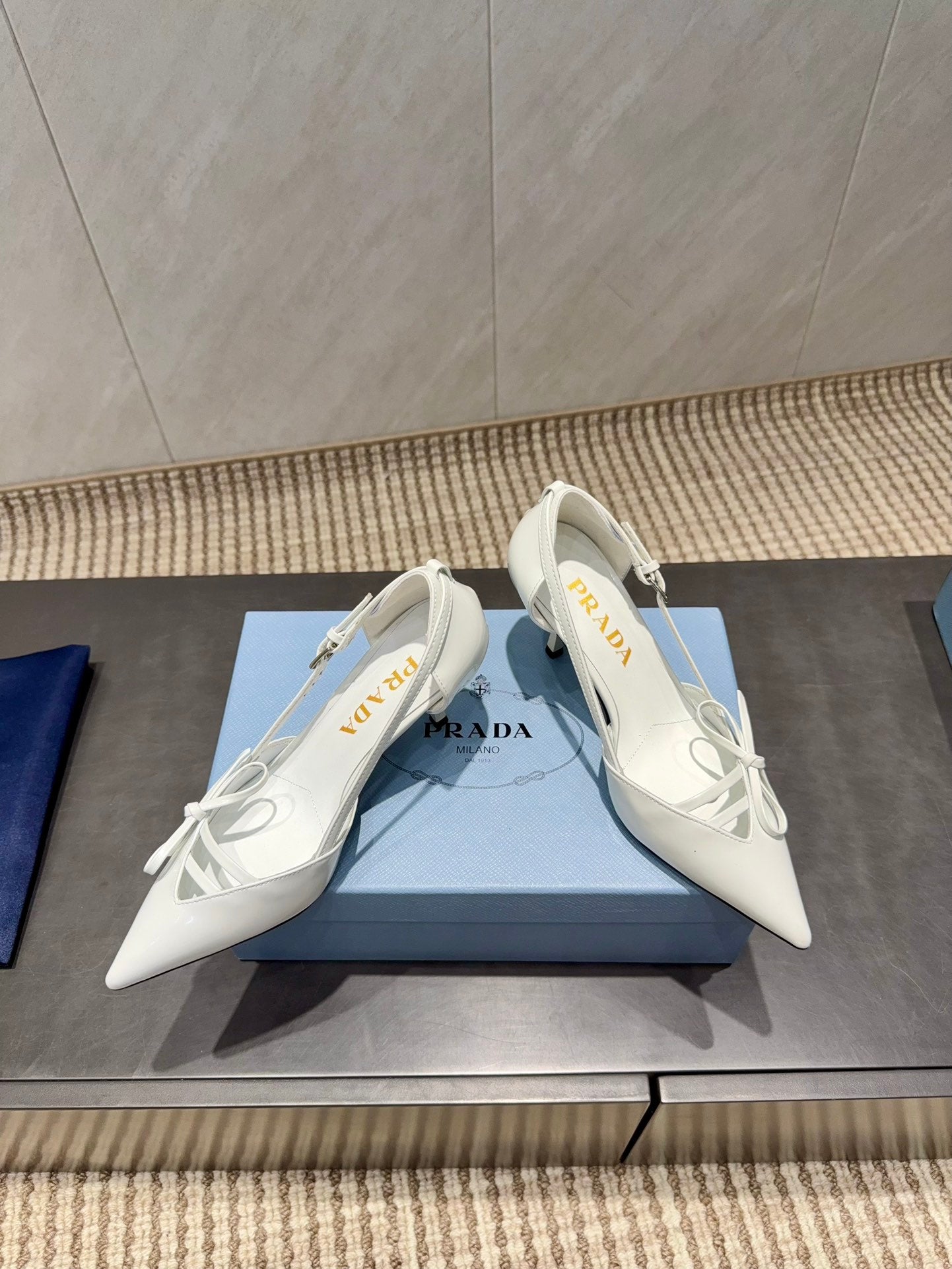 ЖІНОЧІ ТУФЛІ PRADA 26S НА ВИСОКИХ ПІДБОРАХ 75 ММ ІЗ ЗАГОСТРЕНИМ НОСКОМ ТА ВИРІЗАМИ З БІЛОЇ ТЕЛЯЧОЇ ШКІРИ З БАНТОМ