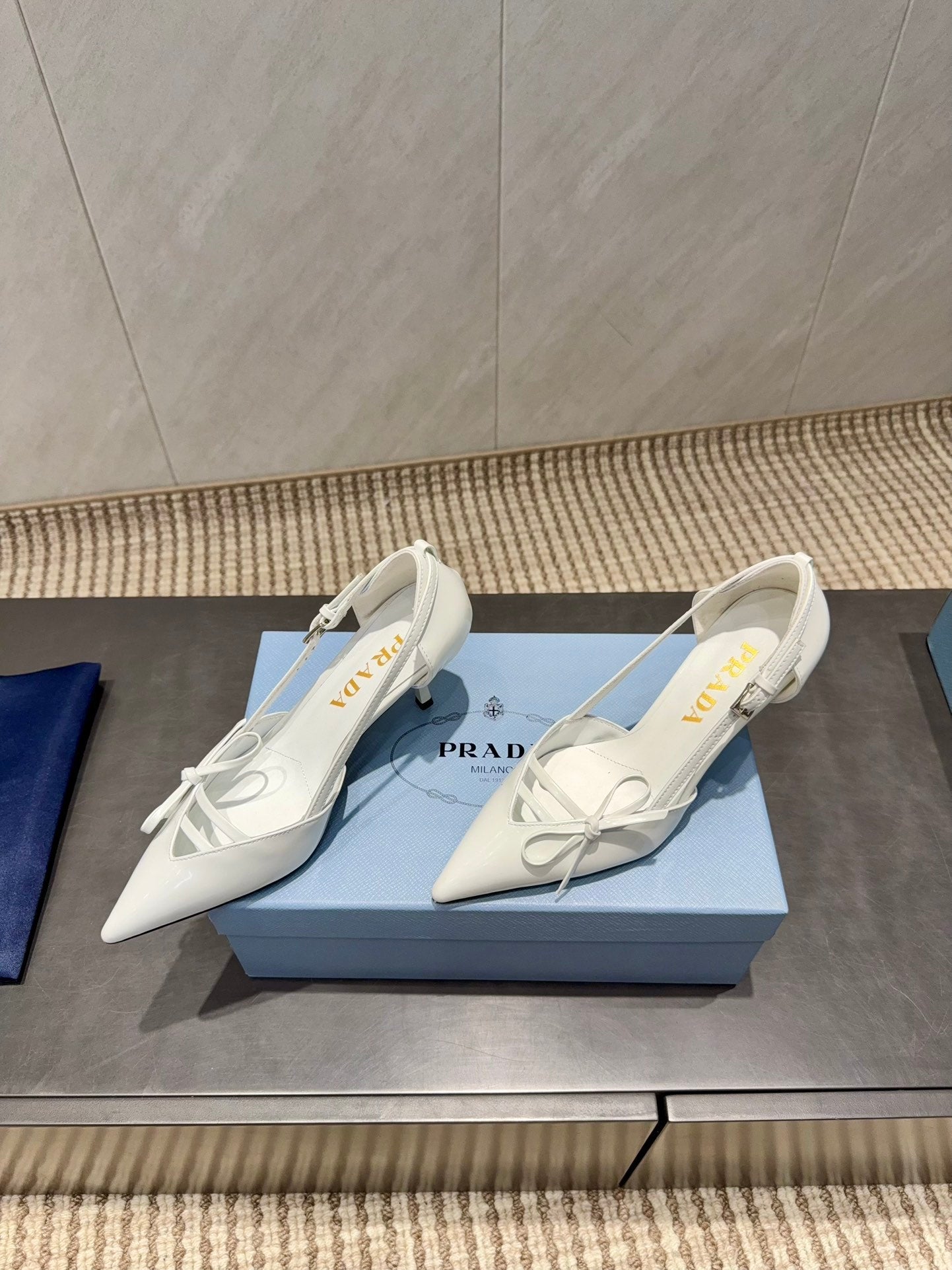 ЖІНОЧІ ТУФЛІ PRADA 26S НА ВИСОКИХ ПІДБОРАХ 75 ММ ІЗ ЗАГОСТРЕНИМ НОСКОМ ТА ВИРІЗАМИ З БІЛОЇ ТЕЛЯЧОЇ ШКІРИ З БАНТОМ