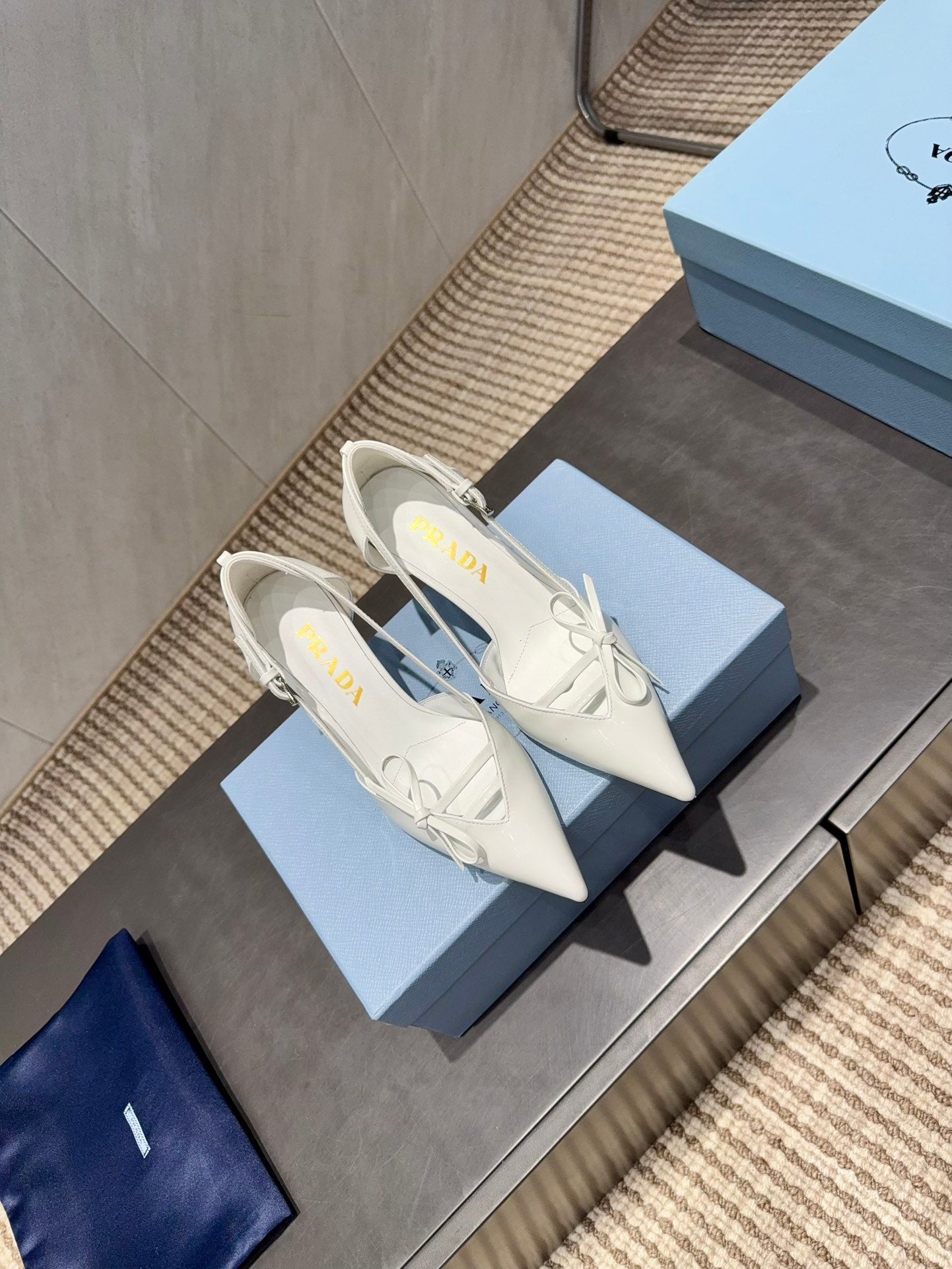 ЖІНОЧІ ТУФЛІ PRADA 26S НА ВИСОКИХ ПІДБОРАХ 75 ММ ІЗ ЗАГОСТРЕНИМ НОСКОМ ТА ВИРІЗАМИ З БІЛОЇ ТЕЛЯЧОЇ ШКІРИ З БАНТОМ