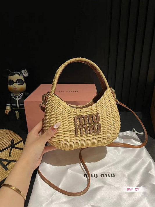 Woven handbag with 'MIU MIU' logo held by a hand, with a black background and pink box.