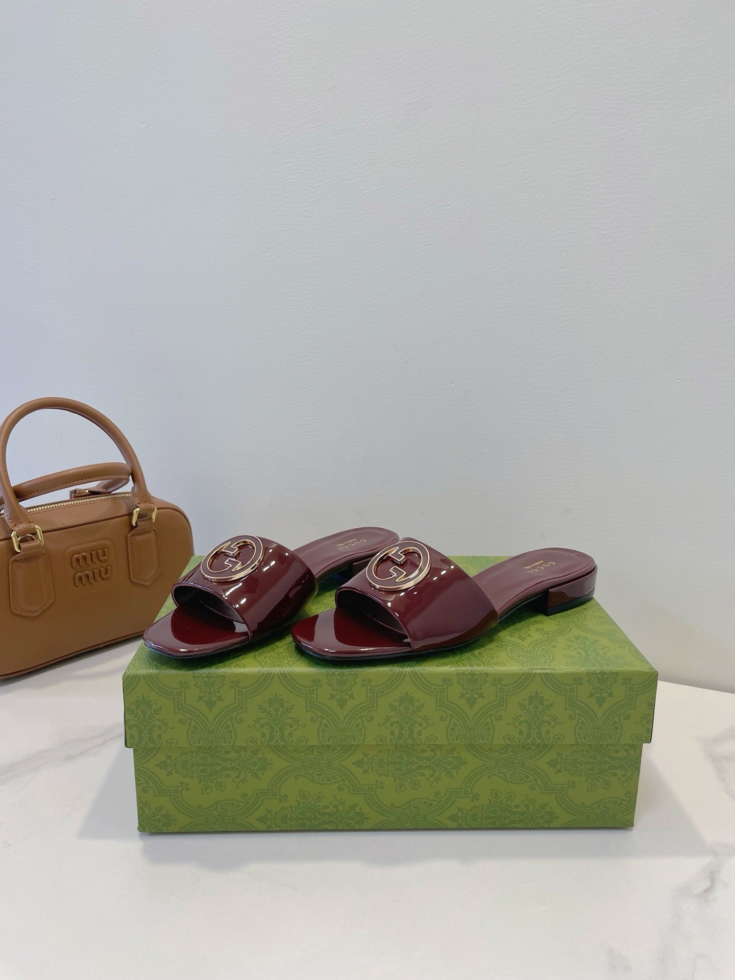 SLIDE SANDALS IN WINE RED GLOSSY SHEEPSKIN ENAMELLED ROUND INTERLOCKING G - 35