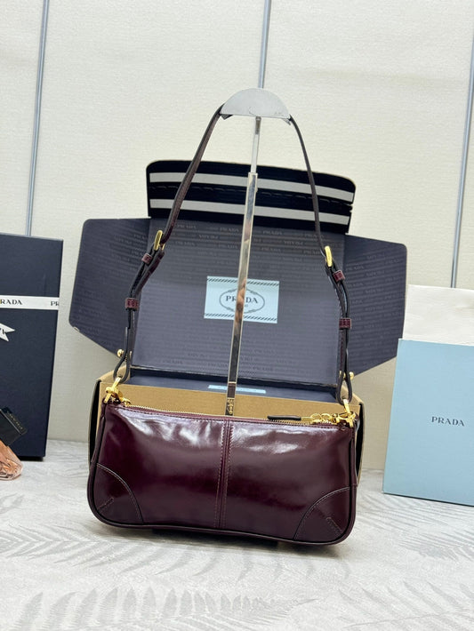 ЖІНОЧА СЕРЕДНЯ СУМКА PRADA 25S RE-EDITION 2002 З ТЕЛЯЧОЇ ШКІРИ БОРДОВОГО КОЛЬОРУ ІЗ ЗОЛОТОЮ ФУРНІТУРОЮ