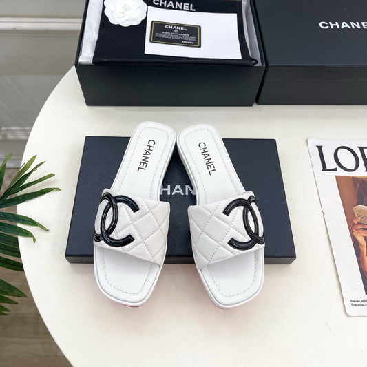 CHANEL 26S ПЛОСКІ ШЛЬОПАНЦІ З БІЛОЇ ШКІРИ ЯГНЯТИ З ЧОРНИМ ЛОГОТИПОМ CC